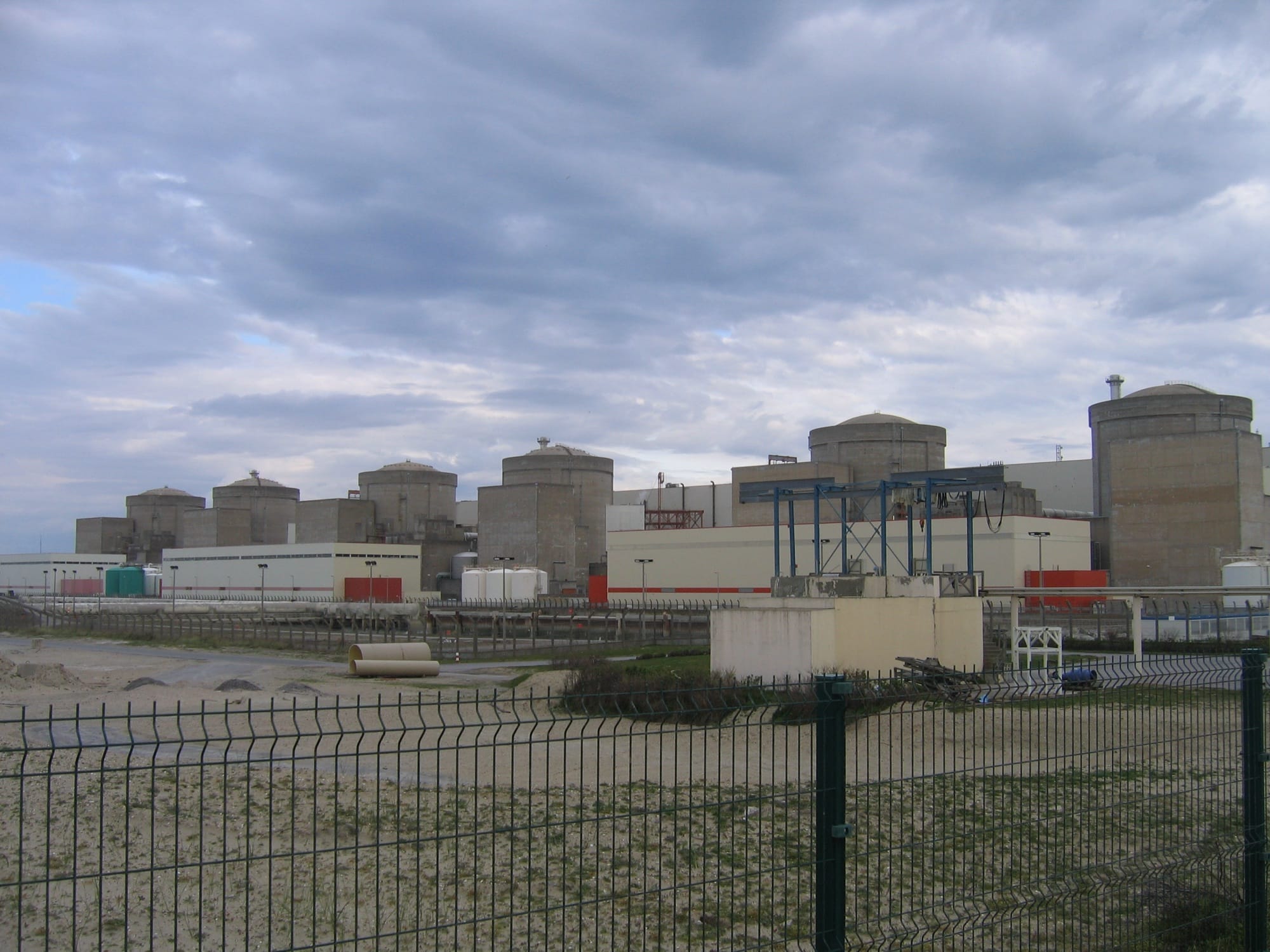 The six reactor buildings of the Gravelines nuclear power plant behind its perimeter fence